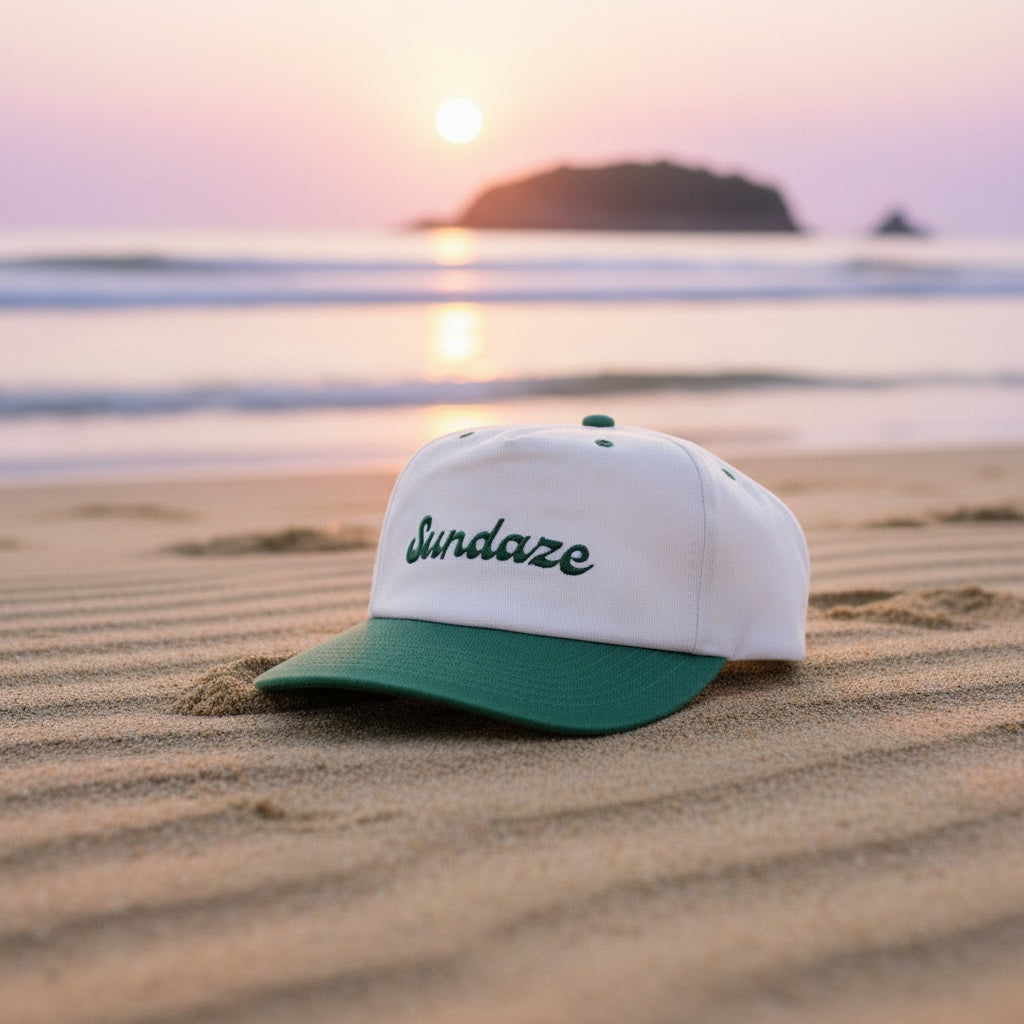 White and green cap with 'Sundaze' logo on a wooden stump in a forest setting